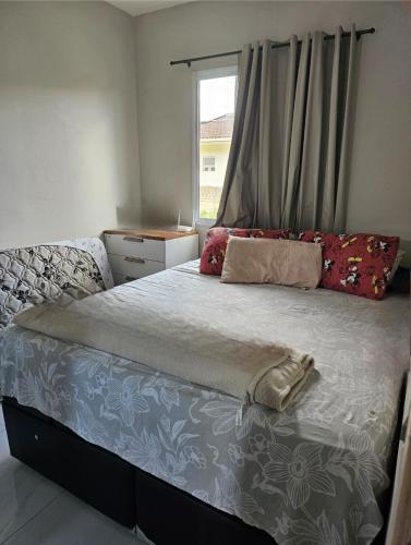 a bedroom with a large bed with a window at Casa Ananin in Ananindeua