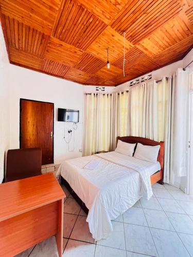 a bedroom with a bed and a wooden ceiling at Terrassa Village in Kigali