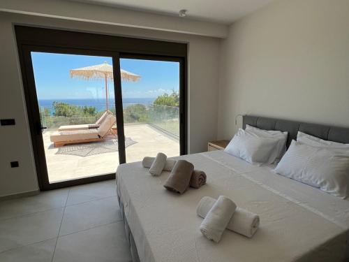 a bedroom with a bed with a view of a patio at Thalassa Haven Lourdas in Lourdhata
