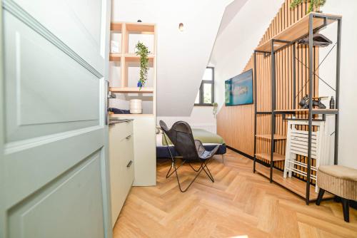 a room with a staircase and a room with a chair at Homly Nook in Rīga