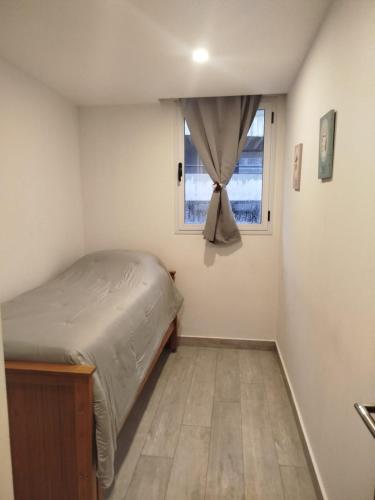 a small bedroom with a bed and a window at Zeus II Pinamar in Pinamar