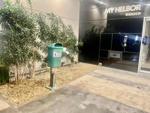 a green trash can in front of a building at Conexão Total A 500m da Estação 5 Min Super Shopping Proximidade Alphaville in Osasco