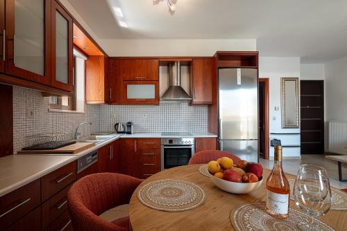 a kitchen with a wooden table with a bowl of fruit at Light House Chania - 5 Min to Beach and Free Parking in Chania Town
