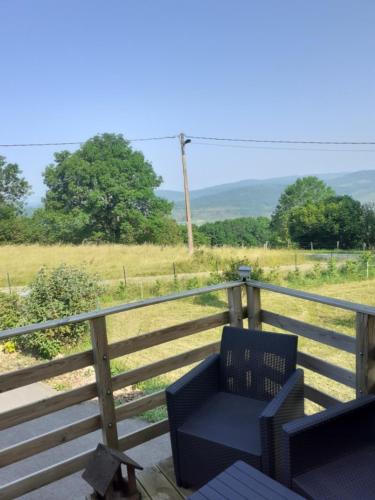 a blue chair sitting on a deck with a view of a field at Chalet a la montagne in Cornod