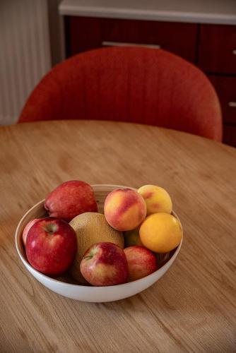 a bowl of apples and pears on a table at Light House Chania - 5 Min to Beach and Free Parking in Chania Town