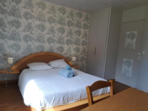 Un dormitorio con una cama con un osito de peluche azul encima. en Chambre Les Terrasses de Condate, en Rennes