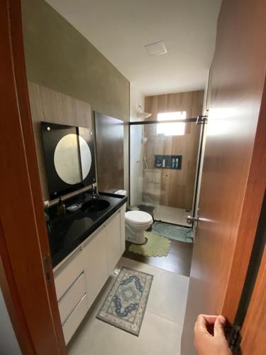 a bathroom with a toilet and a sink and a mirror at Casa House Cop 30 in Ananindeua