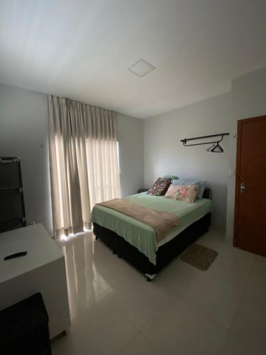 a bedroom with a bed and a window at Casa House Cop 30 in Ananindeua