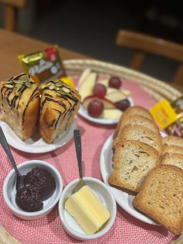 einen Tisch mit Platten aus Brot und Gebäck in der Unterkunft Complejo de Cabañas Aires de Santiago in San Antonio de Arredondo
