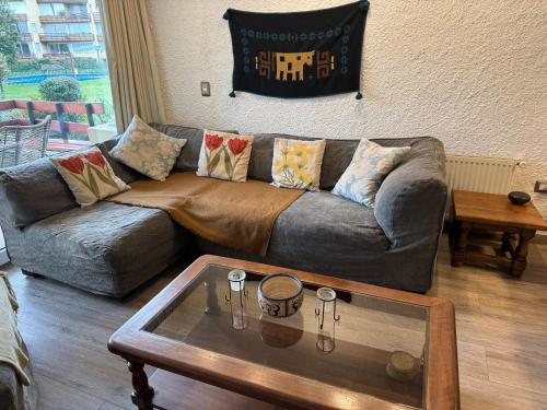 a living room with a couch and a coffee table at La Poza Pucon, a pasos de todo in Pucón