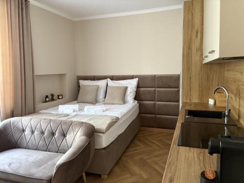a bedroom with a large bed and a chair at Apartamenty Uchnasta in Busko-Zdrój