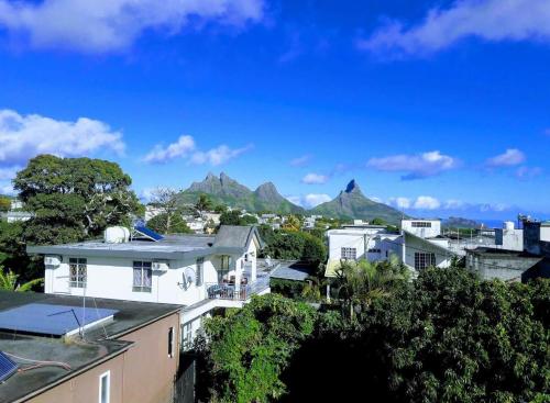 a view of a city with mountains in the background at Family Perfect - Lovely New 2-Bedroom Apartment in Vacoas