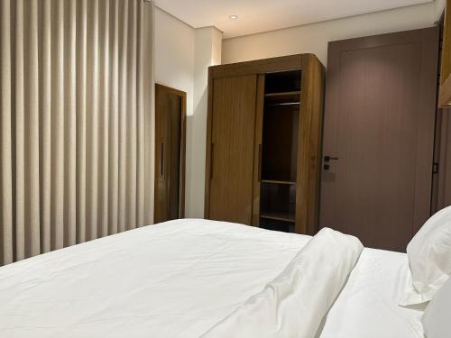 a bedroom with a white bed and a window at أجنحة رافينا هاوس - Ravina Suites in Riyadh