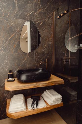 a bathroom with a sink and a mirror and towels at B&b i Parenti in Palmi