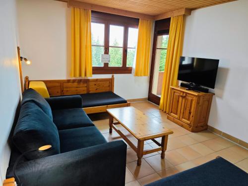 a living room with a couch and a tv at Panorama Apartment Gerlitzen in Treffen