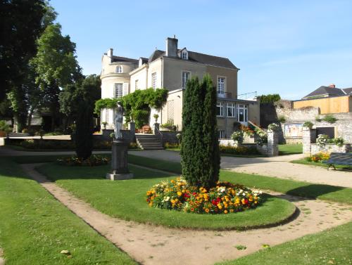 a house with a garden with flowers in front of it at L'Envolée, Proche Gare SNCF, Confort, Netflix in Laval