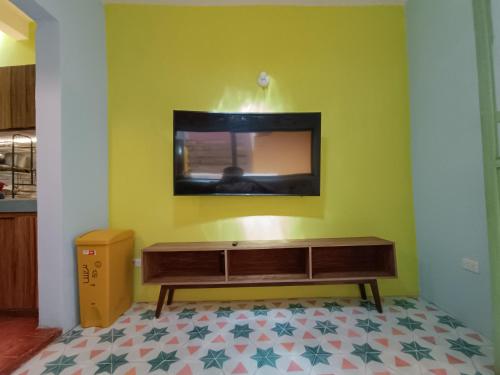 a living room with a tv on a green wall at Casa Tuna in Querétaro