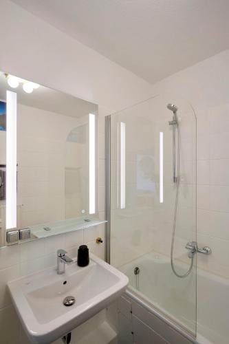 a white bathroom with a sink and a shower at Ferienwohnung Bad Sachsa Harz II in Bad Sachsa