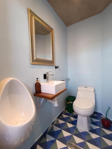 a bathroom with a sink and a toilet and a mirror at Casa Tuna in Querétaro