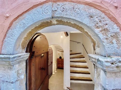 an archway leading to a hallway with stairs at Cabris Village - Elegant Family House in Cabris