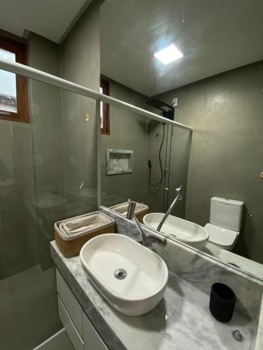 a bathroom with a sink and a toilet and a mirror at Casa Brisa - sossego a 50 mts da Praia da Bombaça em Barra Grande in Marau