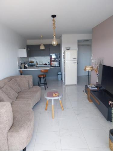 un salon avec un canapé et une table dans l'établissement Le CosY Appart 43M2 Clim Vue Mer Golfe de Saint Tropez, à Cavalaire-sur-Mer