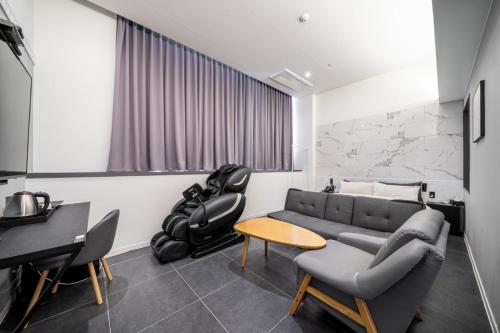 a living room with a couch and a table at Pyeongtaek Stay Tourist Hotel in Pyeongtaek