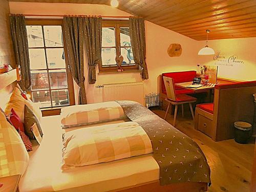 a bedroom with a bed and a desk and a table at Gästehaus Schönfeld in Reit im Winkl