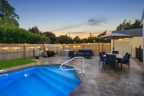 a backyard with a swimming pool and a table and chairs at Cape Escape in Barnstable