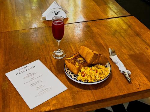 Una mesa con un plato de comida y una bebida. en Casa Charlotte - Alma Hotels, en Santa Marta