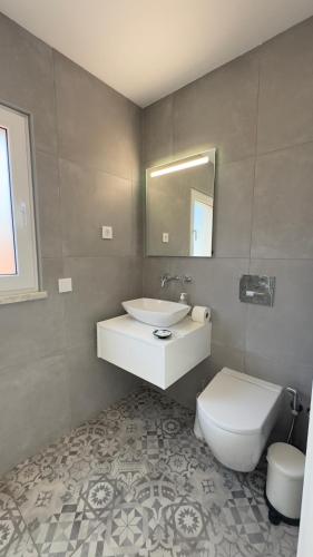 a bathroom with a white sink and a toilet at Vila D`arte Vila de Rei in Vila de Rei