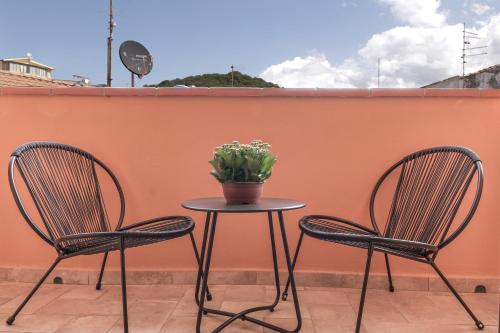 two chairs and a table with a potted plant on it at Via Manno 11 Rooms in Iglesias