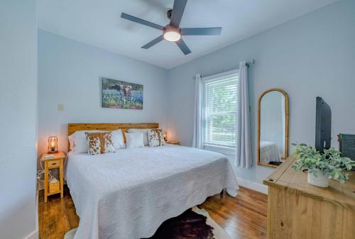 a bedroom with a bed with a ceiling fan at Bandera Bungalow - River, Downtown, Peaceful fenced corner lot! King bed! in Bandera