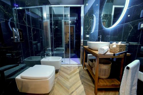 a bathroom with a toilet and a sink and a shower at Via Manno 11 Rooms in Iglesias