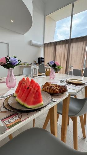a table with two plates of watermelon and pastries on it at Vila D`arte Vila de Rei in Vila de Rei