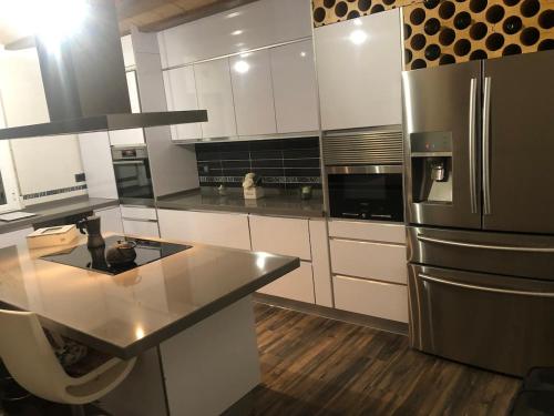 a kitchen with white cabinets and a stainless steel refrigerator at Coparelia in Villarrobledo