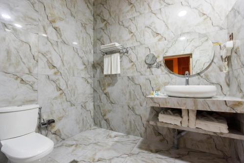 a bathroom with a sink and a toilet and a mirror at Dashli Gala Hotel Ganja in Ganja