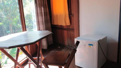 a small kitchen with a table and a small refrigerator at Pousada Alquimia in Aiuruoca