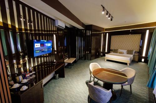 a hotel room with a television and a living room at Dashli Gala Hotel Ganja in Ganja