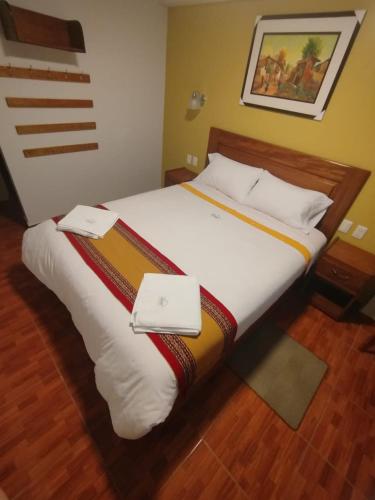 a bedroom with a bed with two laptops on it at Picos House MachuPicchu in Machu Picchu