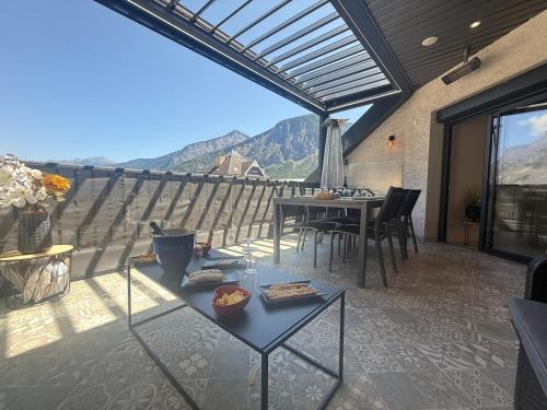 a patio with a table and chairs and a view at Prestige Hyper Centre Veranda Climatisation in Saint-Jean-de-Maurienne
