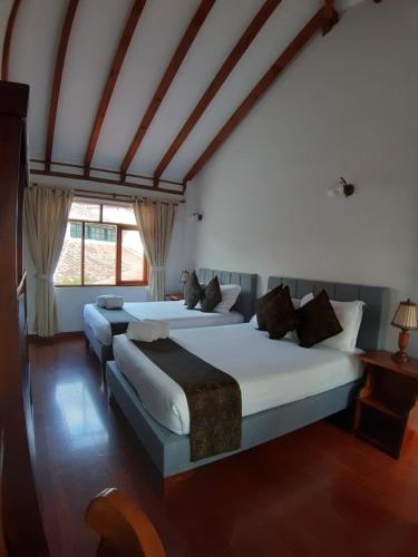 a bedroom with two beds and a window at Hotel El Giro in Villa de Leyva