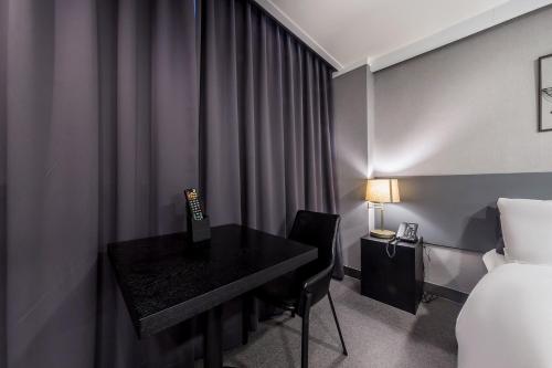 a hotel room with a desk and a bed at Pyeongtaek Stay Tourist Hotel in Pyeongtaek