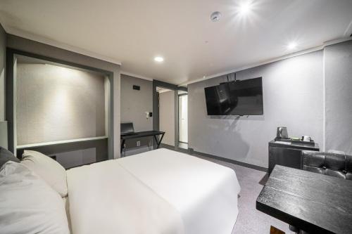 a hotel room with a bed and a television at Pyeongtaek Stay Tourist Hotel in Pyeongtaek