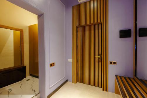 a bathroom with a wooden door and a mirror at Dashli Gala Hotel Ganja in Ganja