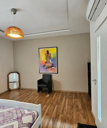 a bedroom with a bed and a painting on the wall at Appartement blue sky unique et élégante in Lomé
