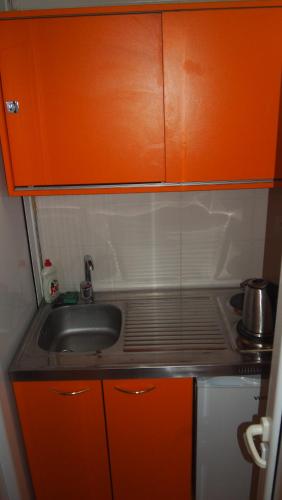 a kitchen with an orange cabinet and a sink at Marko Apartment in Sutomore