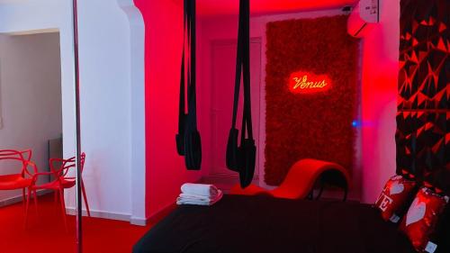 a red room with a table and chairs and a neon sign at Vénus #Love room# in Capesterre-Belle-Eau