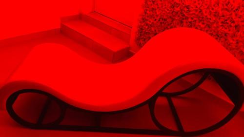 a red chair in a red room with stairs at Vénus #Love room# in Hoguet