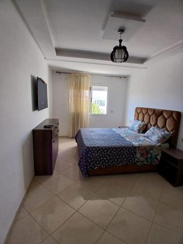 a bedroom with a bed and a television in it at Azure Luxe Retreat in Martil